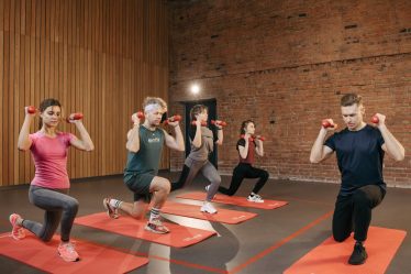 Indoor group workout session with dumbbells focusing on strength and fitness.