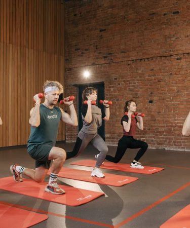 Indoor group workout session with dumbbells focusing on strength and fitness.